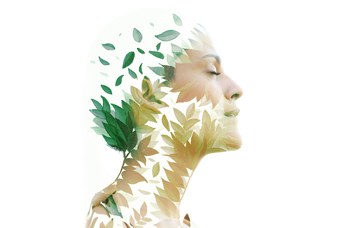Frauenkopf, im Hinterkopfbereich aus grünen Blättern und weißem Hintergrund schaut mit geschlossenen Augen in die Zukunft.