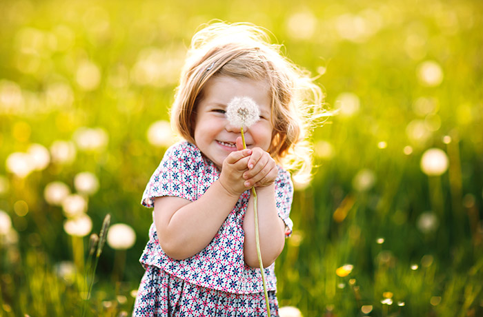 Kind mit Pusteblume freut sich über das Leben