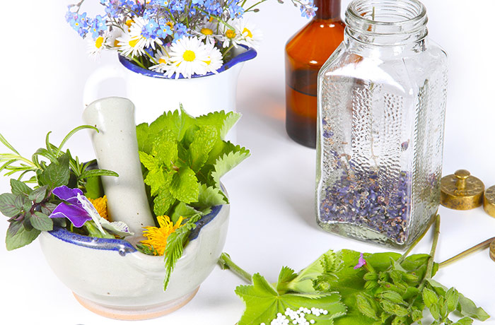 Blumen, Kräuter, Mörser, Vorratsflaschen und Globuli sind häufige Hilfsmittel des Heilpraktikters